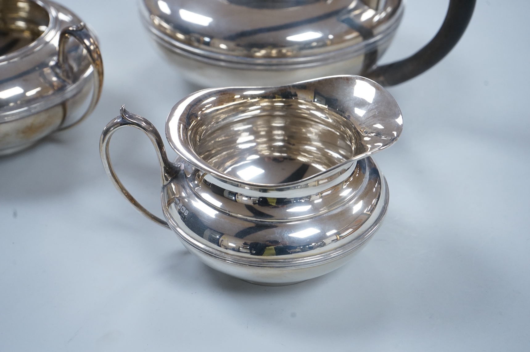 A George V three piece silver tea set, each piece of compressed globular form by James Dixon and Sons, Sheffield 1910, 1025g gross